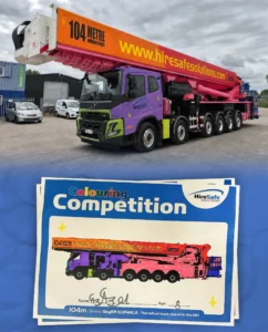 Colorful truck-mounted boom with a pink boom and purple cab parked in a yard, advertising '104 metre working height' and 'hiresafe solutions' on the boom edge.
