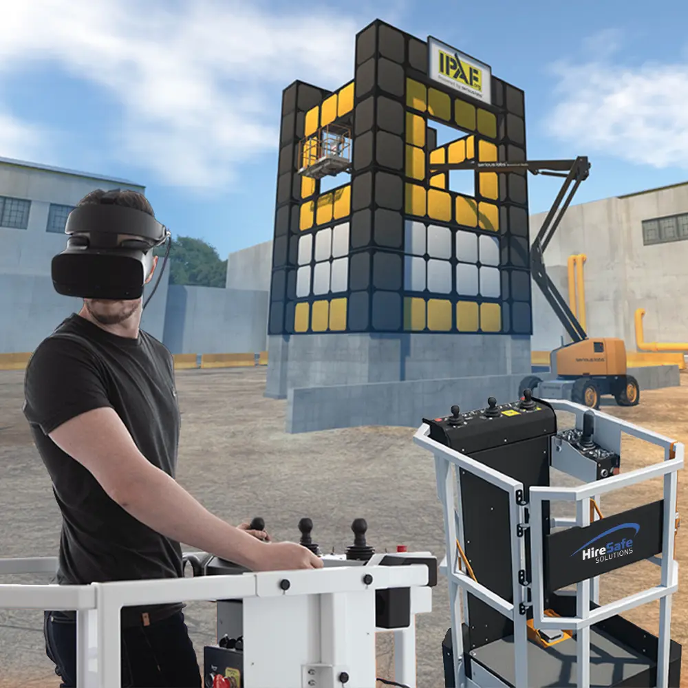 Person wearing a VR headset operates a control station outdoors for crane operator training, with a tall modular scaffold in the background and HireSafe Solutions equipment nearby