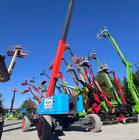 Multiple tall, colorful aerial boom lifts with extended arms in a sunny yard against a clear blue sky.
